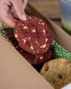 a person picking up some cookies in a box