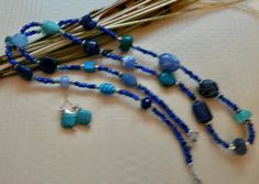 This 36 inch necklace is made from small dark blue beads with other larger beads in turquoise, light blue, and dark blue. There are also silver accent beads. It has a small toggle clasp. The matching earrings are included. This long necklace will look great with blues, white, black and beige. It is very versatile. Blue Hand-strung Beads For Jewelry Making, Blue Beaded Lapis Lazuli Jewelry, Blue Lapis Lazuli Beads In Bohemian Style, Blue Oval Faceted Bead Jewelry, Bohemian Blue Lapis Lazuli Beads, Blue Lapis Lazuli Bohemian Beads, Blue Jewelry With Oval Natural Stones, Blue Natural Stone Beaded Necklaces With Oval Beads, Blue Beaded Dangle Necklaces With Natural Stones