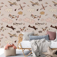 an airplane themed wallpaper in a child's bedroom with a bed and chair