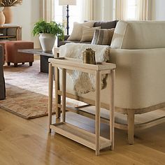 a living room filled with furniture and a wooden table on top of a hard wood floor