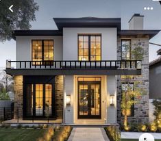 an image of a modern house with lights on the front door and windows in the back