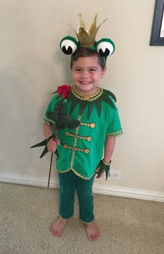 a little boy dressed up as a frog holding a rose