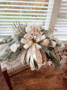 a bouquet of flowers sitting on top of a wooden bench in front of a window