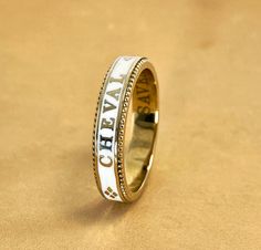 A slim stackable version of our Equus Enamel Ring. Beautiful combination of white enamel and 18 karat yellow gold. 4mm wide Equus (Latin for horse) Cheval (French for horse), stars and a snaffle bit in a continual pattern. Fine beaded detail on both edges. Absolutely gorgeous stacked with the Slim Lace Rein & Diamond Stack rings! Create your own combination! Hand made in the US Made to order, please allow 4-6 weeks for delivery. Luxury Vintage Enamel Ring, White Luxury Enamel Ring For Formal Events, White Enamel Stackable Ring, White Stackable Enamel Ring, Luxury Gold Enamel Ring, Luxury Hallmarked White Gold Enamel Ring, Luxury White Gold Enamel Ring In 14k Gold, Luxury Engraved Yellow Gold Enamel Ring, Luxury Gold Engraved Enamel Ring