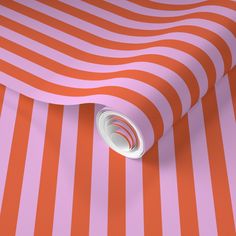 an orange and pink striped wallpaper with a white hole in the center on it