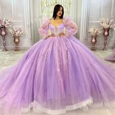 a woman in a purple ball gown with long sleeves