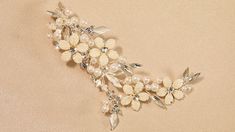 Pearl Bridal Comb Envogue HC2524 This beautiful 5" long bridal hair comb will be the perfect accessory to complete your modern bridal ensemble. The hand-wired, rhodium plated floral design boasts rum pink painted leaves, lustrous ivory pearls, seed beads and sparkling rhinestones. This headpiece will be a romantic accessory to your elegant wedding gown. Size: 5" long and 2 1/2" wide. Color: Silver/Ivory/Rum Pink. Style: HC2524. The earrings shown on the model are our 4" pearl earrings E2551 . Please allow about a week for delivery. Shipping Policy . Return Policy. Floral Bridal Comb, Quinceanera Accessories, Winter Wedding Accessories, Pearl Bridal Comb, Beaded Wedding Veils, Fingertip Wedding Veils, Elegant Wedding Gown, Long Bridal Hair, Rose Gold Bridesmaid