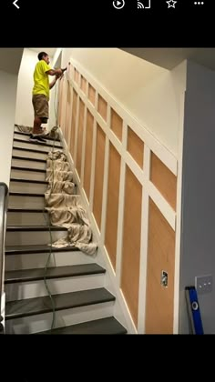 a man in yellow shirt painting stairs with white paint