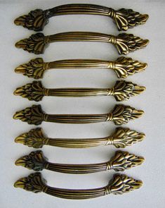 This is a Group of 8 Handles. Made by Amerock Hardware Co. They have an Antique Brass finish and a Wheat - Leaf design. Each measures 5-1/2 inches long and has 3 inches from Center to Center screw holes. Come with screws. These Drawer Pulls are in great used condition, but do have Scuffs, Scratches and wear from use. Click here to see more of my Antique Brass Pulls - Handles & Hardware Listings: https://www.etsy.com/shop/RocktheJewels?ref=seller-platform-mcnav&section_id=17277172 If you need more information or have a question, just jot me a note.  Check out my Shop for more Hardware and DIY treasures; https://www.etsy.com/shop/RocktheJewels And if you're looking for Vintage Flatware, Cutlery & Home pieces?? Check out my other shop; https://www.etsy.com/shop/FabVintageHomeFinds?ref=seller- Amerock Hardware, Antique Brass Pulls, Vintage Flatware, Old Dressers, Brass Pulls, Antique Hardware, French Provincial, Pull Handle, Drawer Knobs