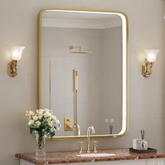 a bathroom sink with a large mirror above it and flowers in a vase on the counter