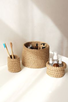 two baskets with toothbrushes and lotion bottles in them sitting on a counter