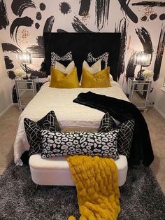 a black and white bedroom with yellow pillows on the bed, carpeted flooring