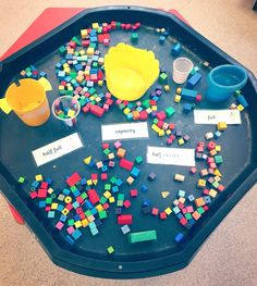 a child's play table with legos on it and name tags attached to the tray