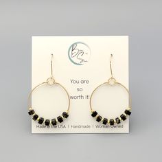 These gold hoops, adorned with black jasper beads, add a touch of eclectic elegance to any outfit. Perfect for any boho babe, these earrings are a must-have for your collection. 14k Gold Filled Wire Measure approximately 1.125" in diameter Earrings Hang 1.75" from top of ear wire Black Jasper Gemstones Polished to a high shine Sent in a Gift Box with Polishing Cloth Handmade in Montana Montana Jewelry, Eclectic Elegance, Black Jasper, Jasper Beads, Jasper Gemstone, Gold Hoops, Jewelry Packaging, Ear Wire, Christmas Shopping