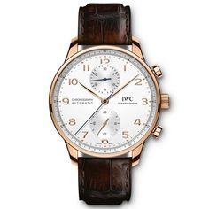 The Portugieser Chronograph is one of IWC Schaffhausen's most iconic models. With its compact diameter of 41 millimeters, it fits almost any wrist. However, the thin bezel gives one the impression of wearing a significantly larger watch. The clear, functional dial boasts applied Arabic numerals and slender Feuille hands. Printed with a quarter-second scale, the characteristic rehaut not only allows precise reading of the stop time but also reminds us of the Portugieser's origins as a nautical pr Watch Leather Strap, Iwc Schaffhausen, Gold Applique, Iwc Watches, Chronograph Watch Men, Gold Pin, Rose Gold Case, Brown Leather Strap, Gold Case