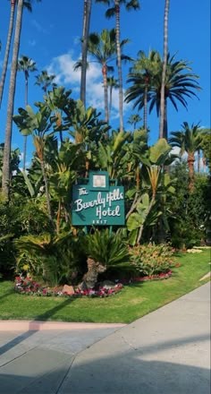 there is a sign that says the beverly hills hotel in front of some palm trees