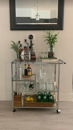 a bar cart with bottles and glasses on it