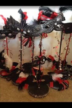 masquerade masks are lined up on the floor in front of a white wall