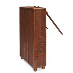 an old wooden cabinet with three drawers and a long stick sticking out of the top