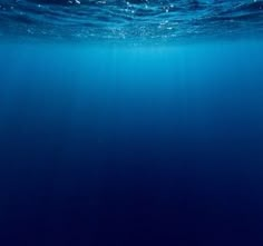 an underwater view of the ocean with blue water