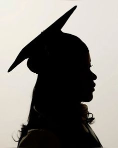 the silhouette of a woman wearing a graduation cap with a bird on it's head