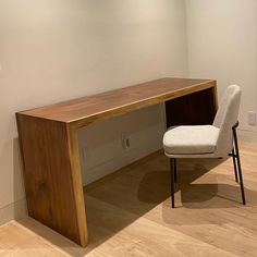 a white chair sitting next to a wooden desk on top of a hard wood floor