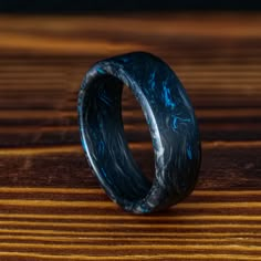 a black and blue ring sitting on top of a wooden table