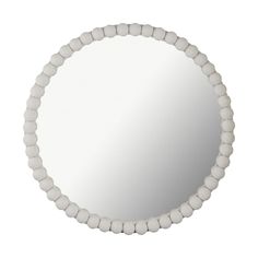 a round mirror with white beads around it