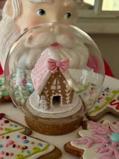 a snow globe with gingerbreads and cookies in the shape of santa's house