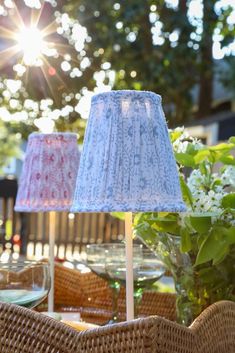 two lamps sitting on top of a table next to a vase with flowers in it