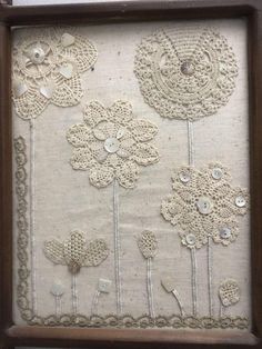 an old frame is decorated with crocheted flowers