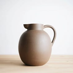 a brown vase sitting on top of a wooden table