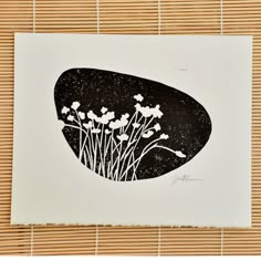 a black and white drawing of flowers on a bamboo mat