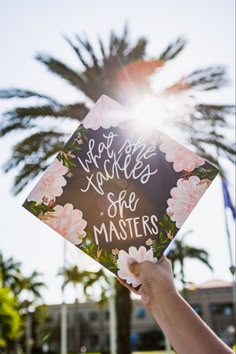 someone holding up a graduation cap that says, not all smiles are masters