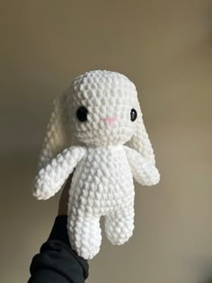 a hand holding a white crocheted stuffed animal