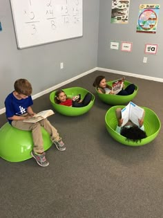 three children reading books in green bowls on carpeted area with gray walls and grey carpet