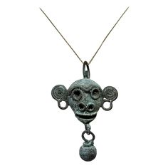 Unveil the elegance of antiquity with this fantastic copper bell pendant cast as the head of a monkey with applied wire facial features from Latin American, Mexico, Mixtec culture, Post-Conquest period, circa mid-16th century. The finely crafted ancient artifact is a testament to the artistry of the Mixtec culture. Spherical bells dangle from the end of each chin and snout, while suspension loops on the top indicate it was intended to be worn on a cord or sewn to clothing. The jangling sound of 16th Century Jewelry, Doll Necklace, Diamond Circle Pendant, Creepy Doll, America Latina, Witch Jewelry, Antique Pendant, A Monkey, Circle Pendant Necklace