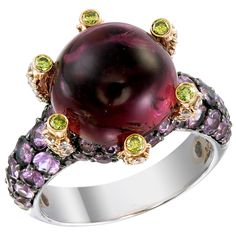 A 10.40-carat round Pink Tourmaline sits high like a colorful crystal ball on a 18k gold and palladium ring protected by 0.14-carat Yellow Diamonds. The ring’s surface is paved with 2.70-carat of Pink Sapphire and 0.59-carat of White Diamonds. This ring, as with all Zorab Creation pieces, are sent with a unique serial number to validate its authenticity. Ring Size 7 1/4 Luxury Rings With Cabochon, Luxury Round Rings With Cabochon, Luxury Multicolor Cabochon Rings, Luxury Round Gemstones For Formal Events, Luxury Round Gemstones For Formal Occasions, Luxury Round Cabochon Amethyst Ring, Luxury Multicolor Amethyst Ring For Formal Occasions, Multicolor Luxury Amethyst Ring For Formal Occasions, Multicolor Cabochon Rings For Formal Occasions