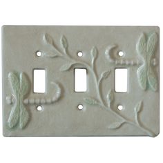 a decorative light switch plate cover with leaves and vines on the front, two toggles