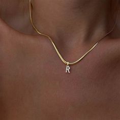 An initial necklace with the extra personality you've been searching for. A shimmering CZ pave initial charm hung on a thick gold snake chain makes this piece perfect for layering. DETAILS & SIZE Finish: 14k gold plate Materials: Stainless steel; CZ stones Measurements: Pendant: 10mm; Chain thickness: 3mm; Chain length: 16" + 2" extension Lobster claw clasp Waterproof, tarnish resistant, nickel free Shop the Personalized Collection! Or shop Necklaces to start your neck stack! Tiny Necklace, Custom Initial Necklace, Initial Necklaces, Choker Style Necklace, Layered Chokers, Initial Necklace Gold, Choker Style, Gold Initial, Jewelry Lookbook