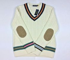 Polo Ralph Lauren Men Preppy Wool Elbow Patch Cotton Cashmere Cricket Sweater This iteration of our signature cricket sweater gets a playful update with colorful contrasting stripes. The elbows are reinforced with herringbone wool woven by Magee 1866, which has been creating authentic tweeds in Ireland for more than 150 years. Regular Fit: wider at the chest while still maintaining a modern silhouette. Sold Out, Very rare item Striped V-neck. Long sleeves with herringbone tweed elbow patches. St Cricket Sweater, Ralph Lauren Preppy, Elbow Patch Sweater, Drip Outfit Men, Evolution Of Fashion, Herringbone Tweed, Elbow Patch, Vintage Preppy, Ralph Lauren Mens