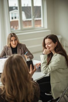 two women sitting at a table talking to each other