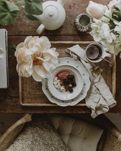 an overhead view of a table with plates and flowers on it, including a teapot