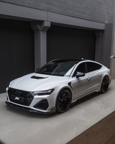 a white car parked in front of a garage