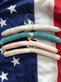 four pieces of fabric are tied together in front of an american flag with stars on it