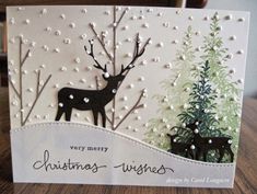 a christmas card with two deers in the background and snow on the ground behind it