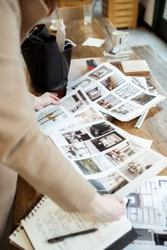 a woman is looking through the pages of a magazine