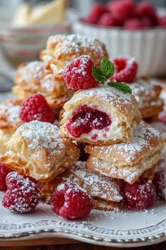 raspberry filled pastries piled on top of each other with powdered sugar