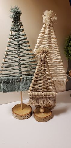 two small christmas trees made out of wicker and wood slices on a white surface