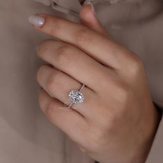 a woman's hand with a diamond ring on it